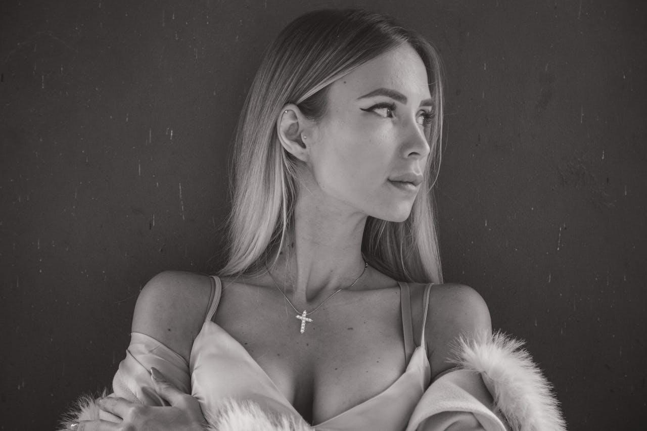 home-hero-1 Stylish black and white portrait of a woman with a cross pendant in Munich.